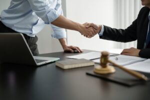 A lawyer shaking hands with a client who is wondering what a personal injury lawyer does.