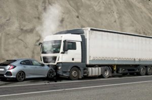 The front of a car colliding with the front of a semi-truck, leaving both drivers to wonder what to do after a truck accident.