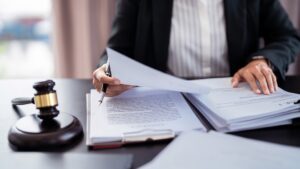A lawyer filing papers at their desk, explaining to a client how to file a personal injury lawsuit.