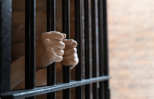 A woman in a women’s prison puts her hand on the bars. The Ryan Law Group can teach you how to join the Chowchilla and Chino women’s prisons sexual abuse lawsuit.